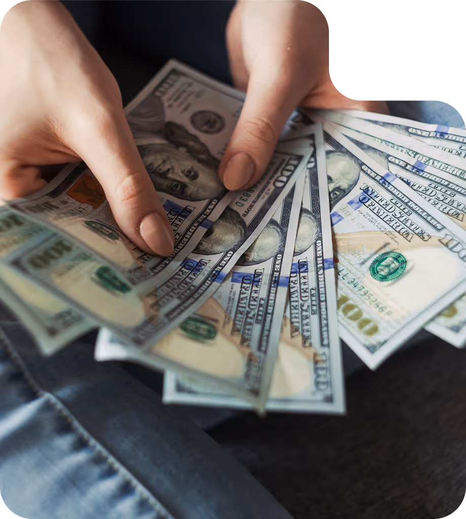 Hands sorting currency notes spread on a surface