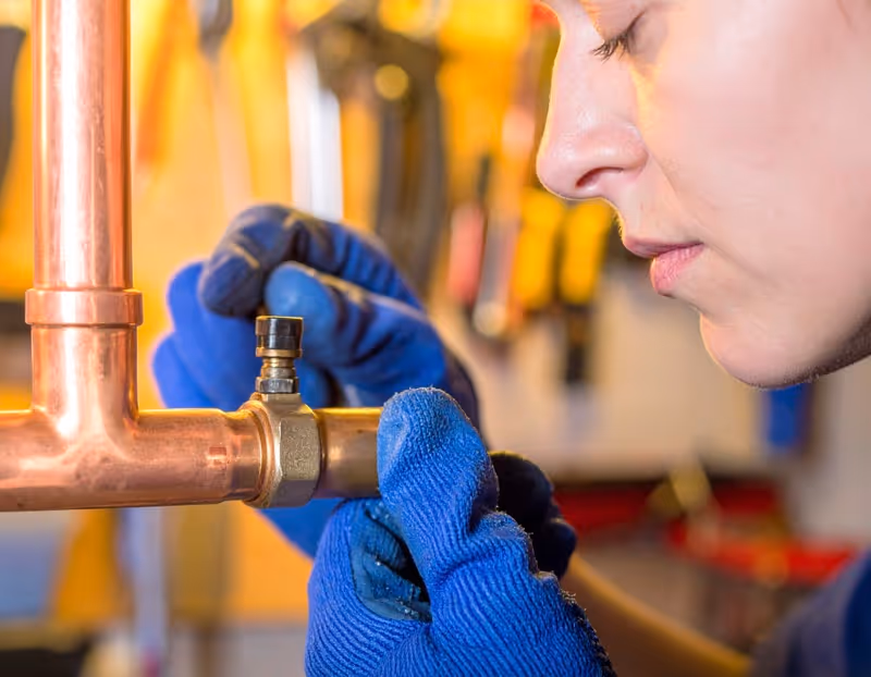 Orlando plumber installing new copper pipe fitting during repair