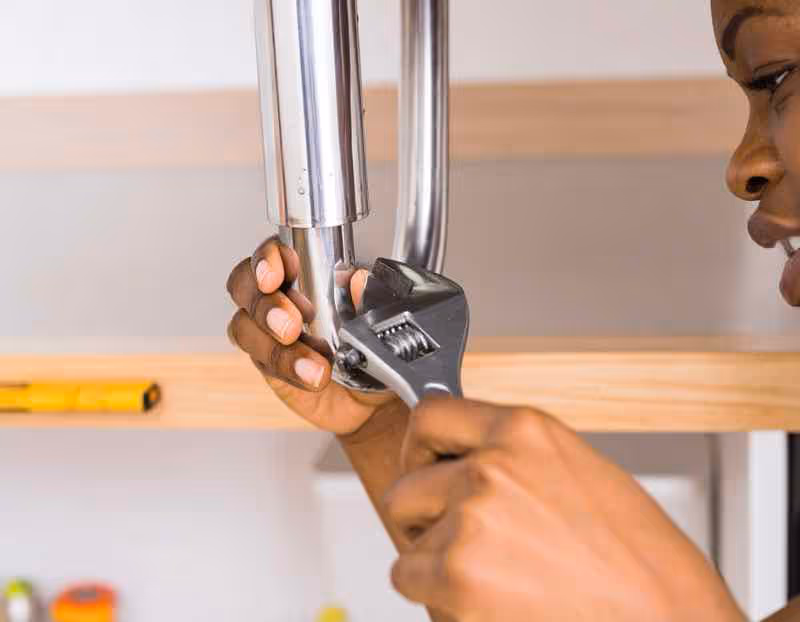 Epoxy putty being applied to small pinhole leak in copper pipe