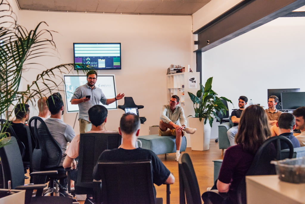 Team members at etalytics engage in a meeting with a presentation in progress, reflecting the dynamic work culture found in etalytics jobs