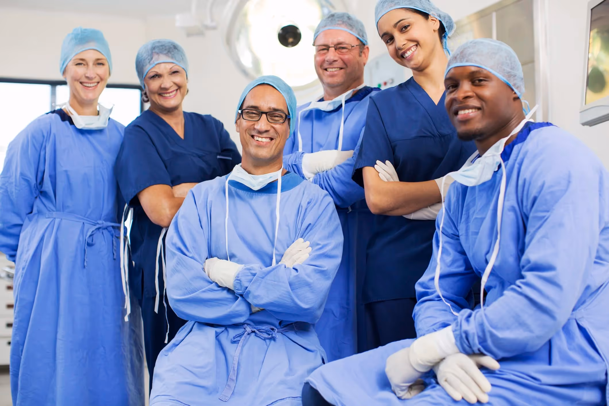 A group of surgeons smiling welcomingly in an operating room