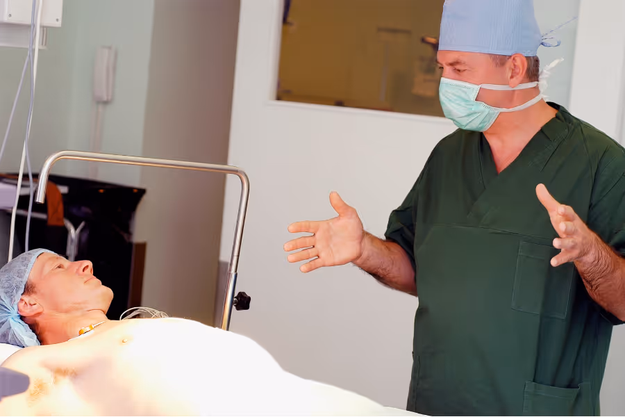 penis surgeon consulting with naked man on hospital bed