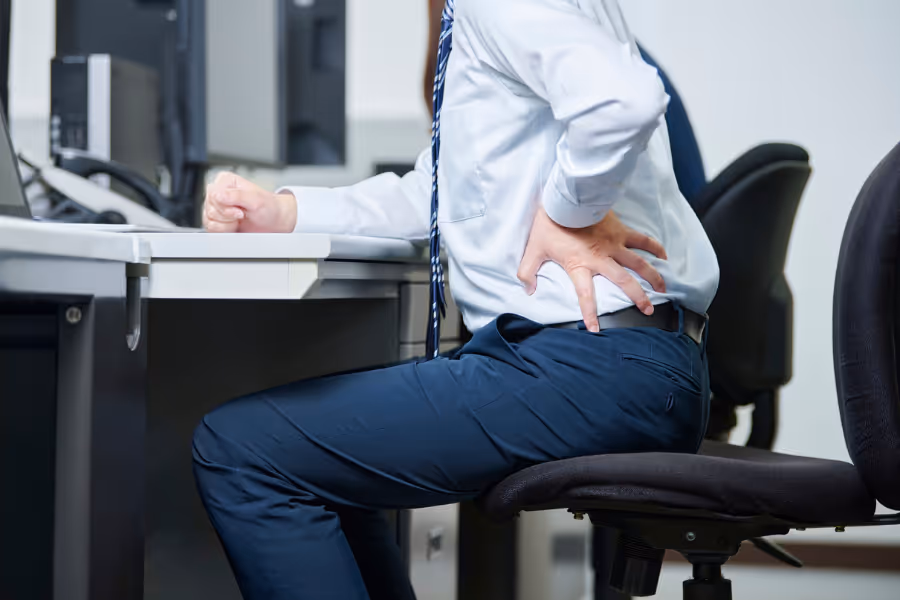 man in suit in hernia pain on his desk chair