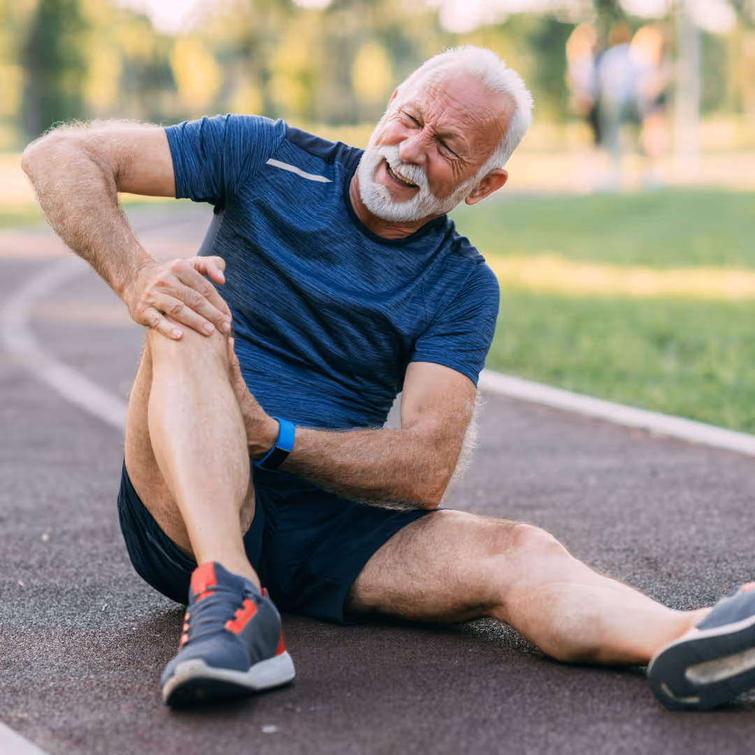 Man holding knee in pain on race track