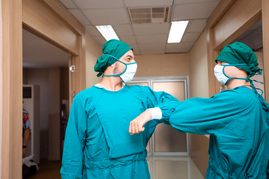 elbow surgeons giving each other an elbow bump in the hall