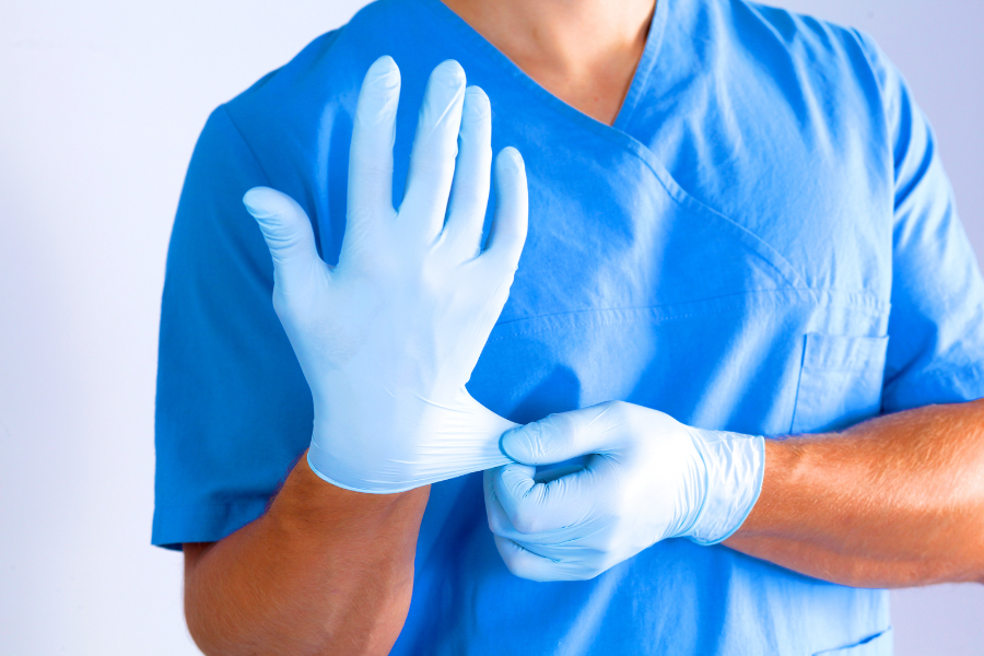 Hand surgeon putting on latex glove