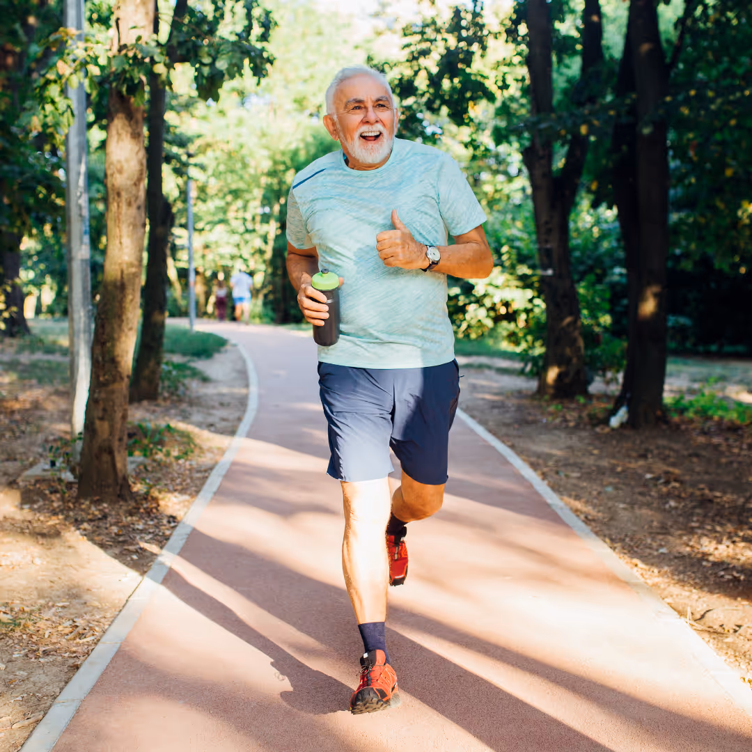 Older man running without hip pain on an outdoor track
