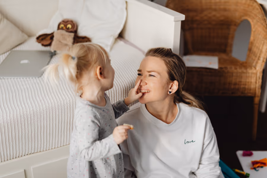 Mom playing with daughter in bedroom