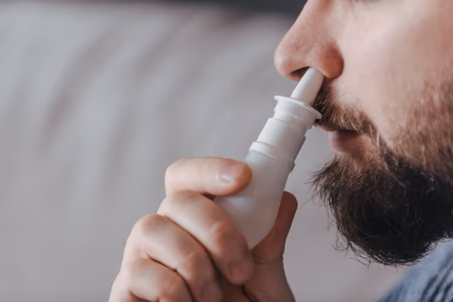 Man using nasal spray post surgery