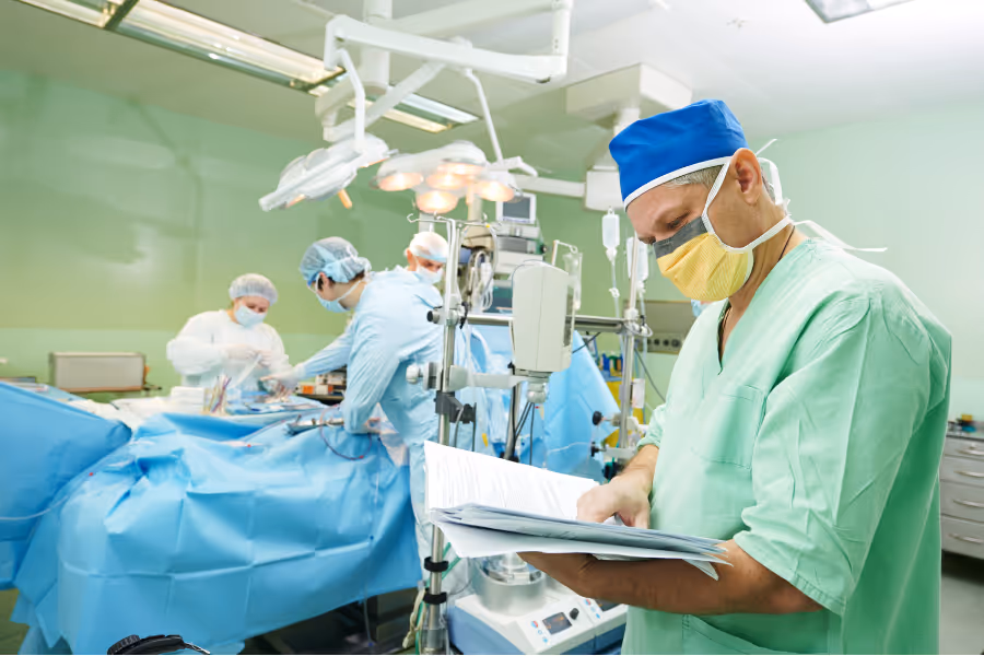 Male surgeon reviewing patient's chart in the operating room