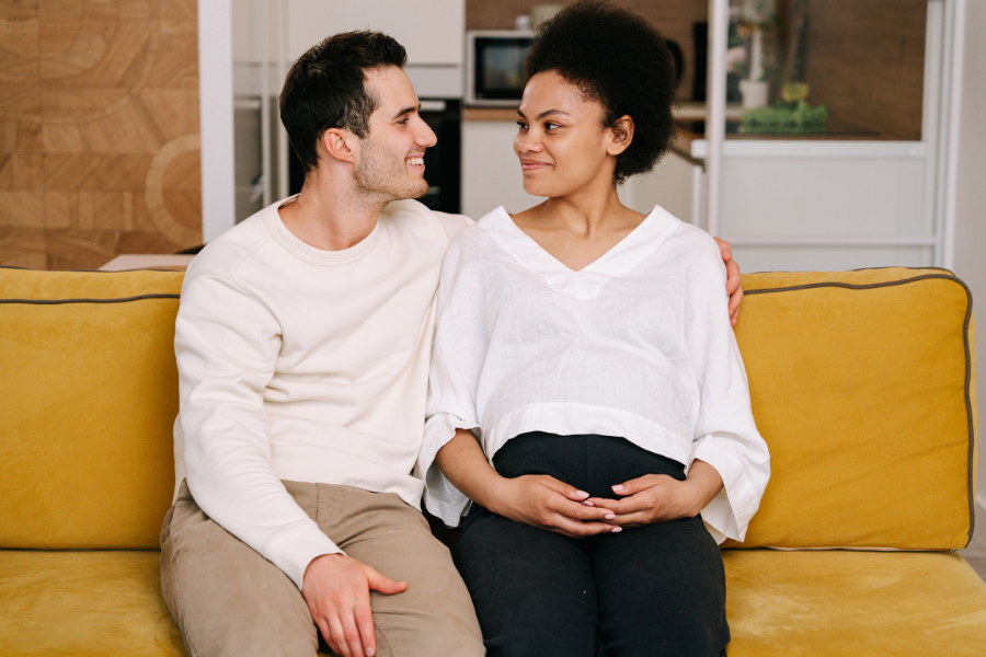 Man and pregnant woman looking lovingly into each other's eyes after resolving urinary incontinence