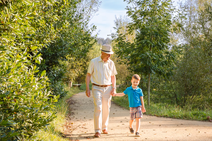 Grandpa walking with his grandson in a park path