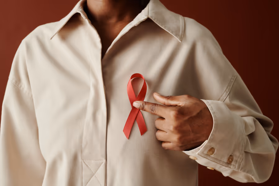 Woman holding pink ribbon next to her breast