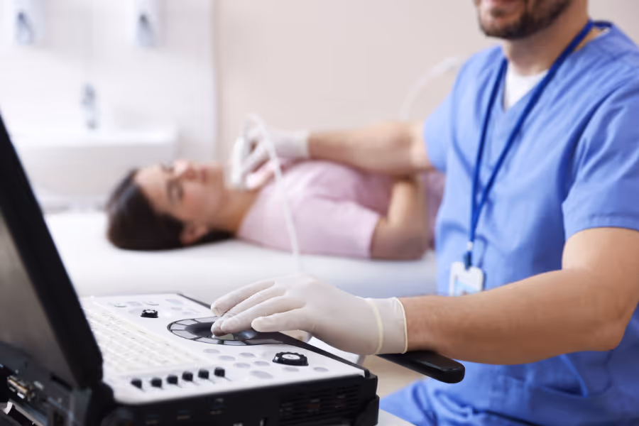 Male sonopgrapher performing private thyroid ultrasound on female patient