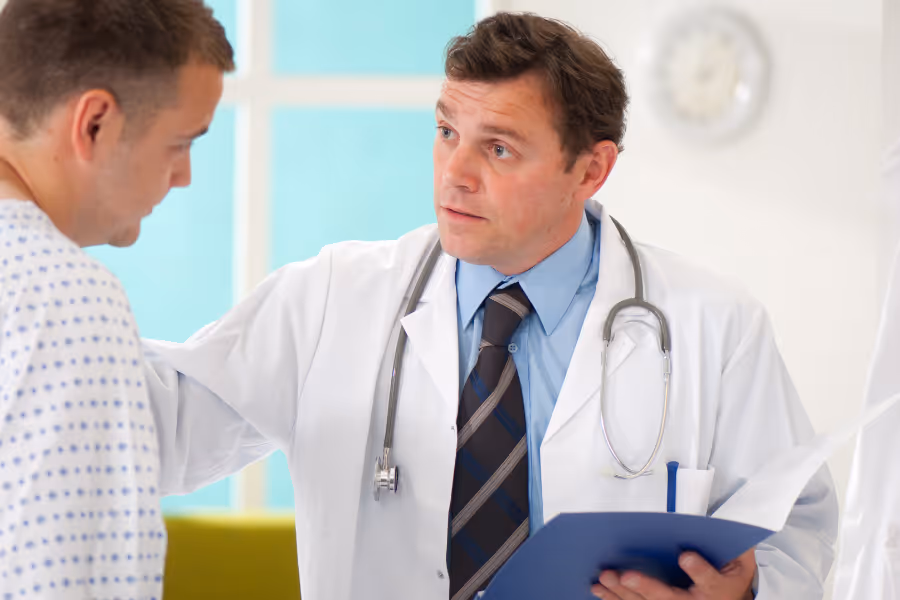 Orthopedic surgeon discussing surgical process with male patient