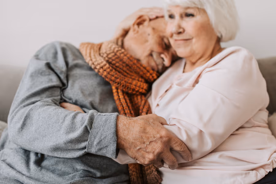 Older couple hugging each other on the couch