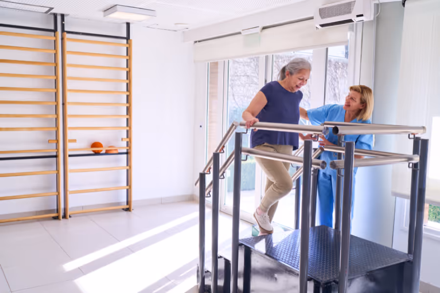 Femme en réadaptation avec un physiothérapeute après une révision d'une arthroplastie de la hanche