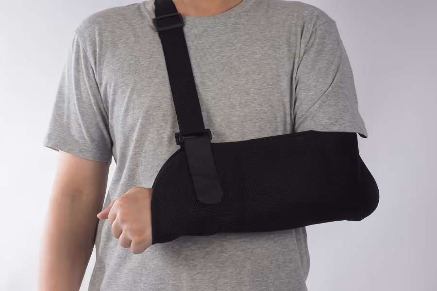Male patient post-elbow replacement surgery in a sling