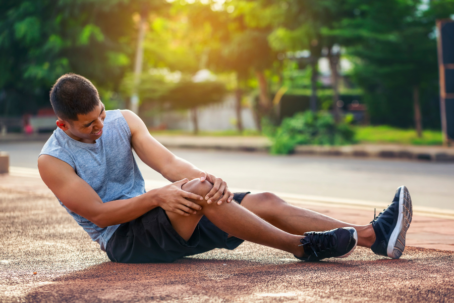 Man in pain on basketball court after sustaining MPFL injury