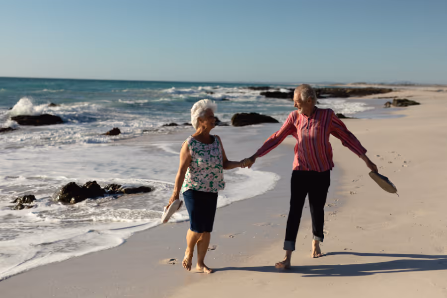 Un couple se promène sur la plage, tous leurs orteils guéris de l'opération
