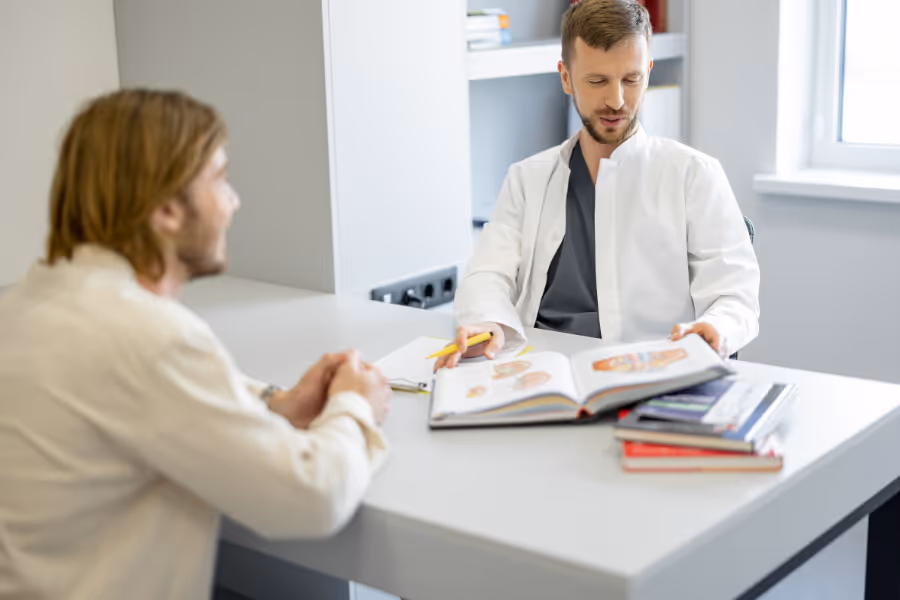 Male patient speaking with private general surgeon in office setting