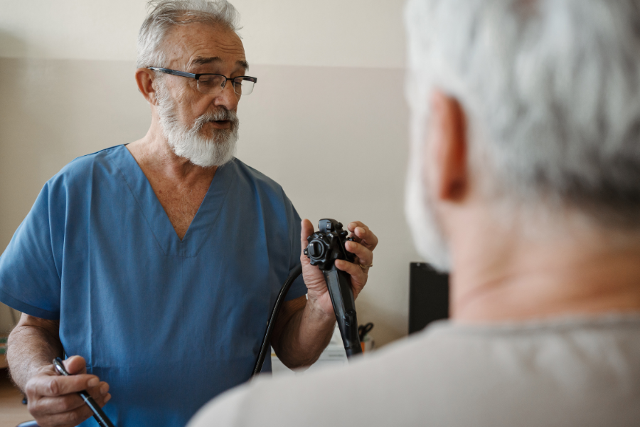 Private colorectal surgeon explaining endoscopy to older male patient