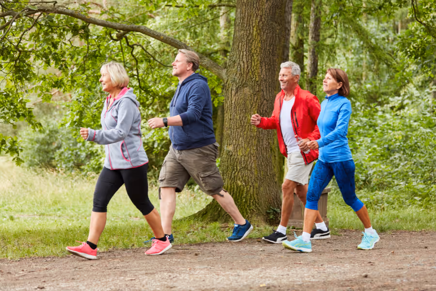 Two older couples running happy on a sunny day