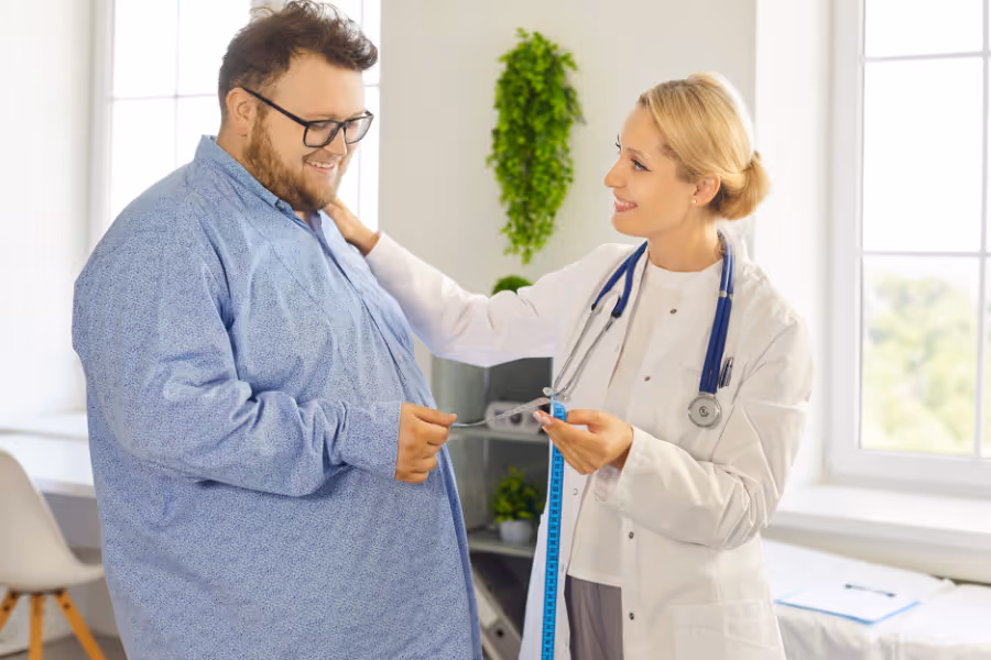 Larger male patient in liposuction consultation with female cosmetic surgeon