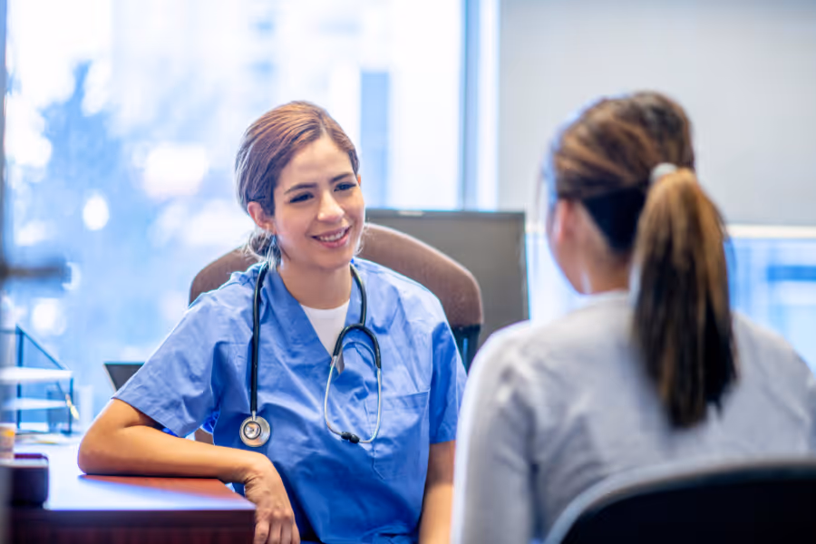 Female cosmetic surgeon consulting with female patient regarding labiaplasty