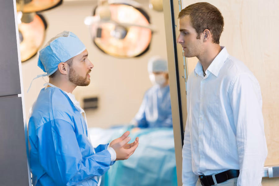 Urologist in scrubs discussing procedure with male patient