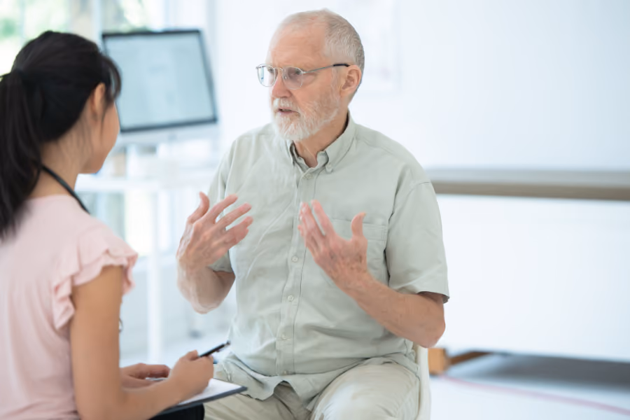 Older male patient speaking with urologist about procedures for prostate BPH