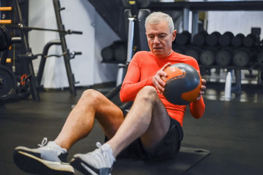 Older male working out in the gym, looking healthy and strong