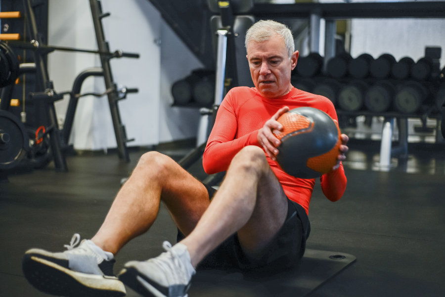 Older male working out in the gym, looking healthy and strong