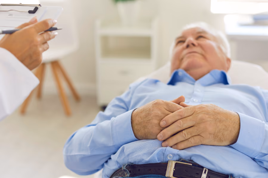 Older male patient lying on exam table for prostate issues