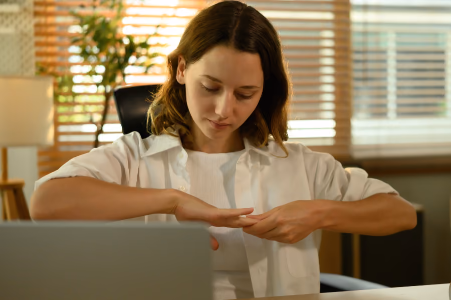 Woman stretching her wrist due to numbness from carpal tunnel.