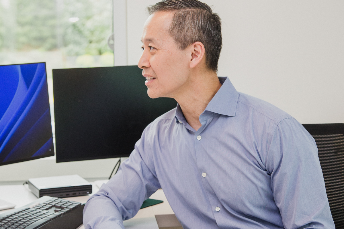 Dr. Lo looking intently across his desk.