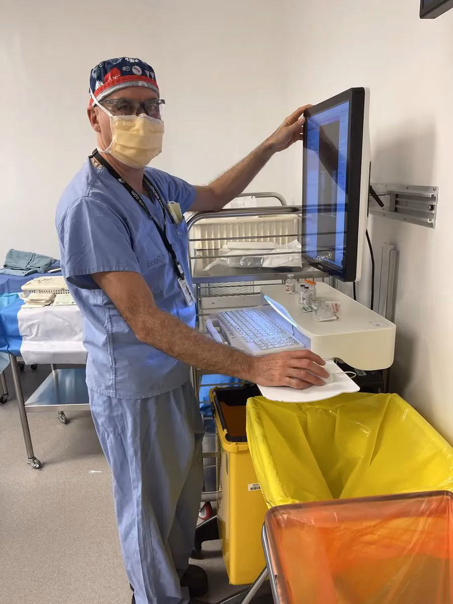 Dr. Paul Zalzal in scrubs on computer in hospital setting