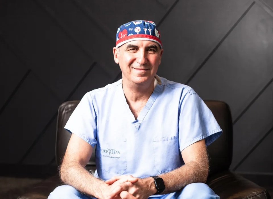 Dr. Zalzal smiling, seated on a black leather couch