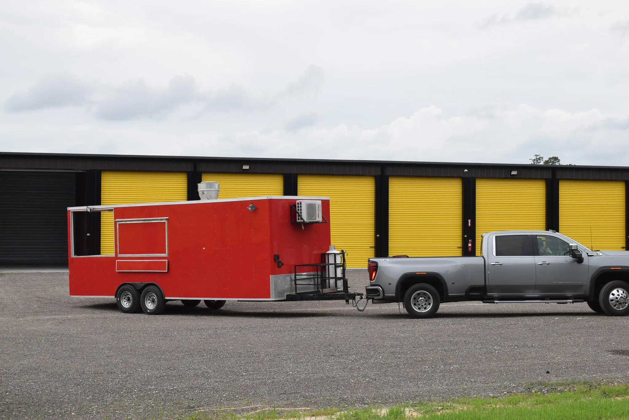 A red food trailer parked beside the storage units during the Foxgate Boat & RV Storage grand opening.