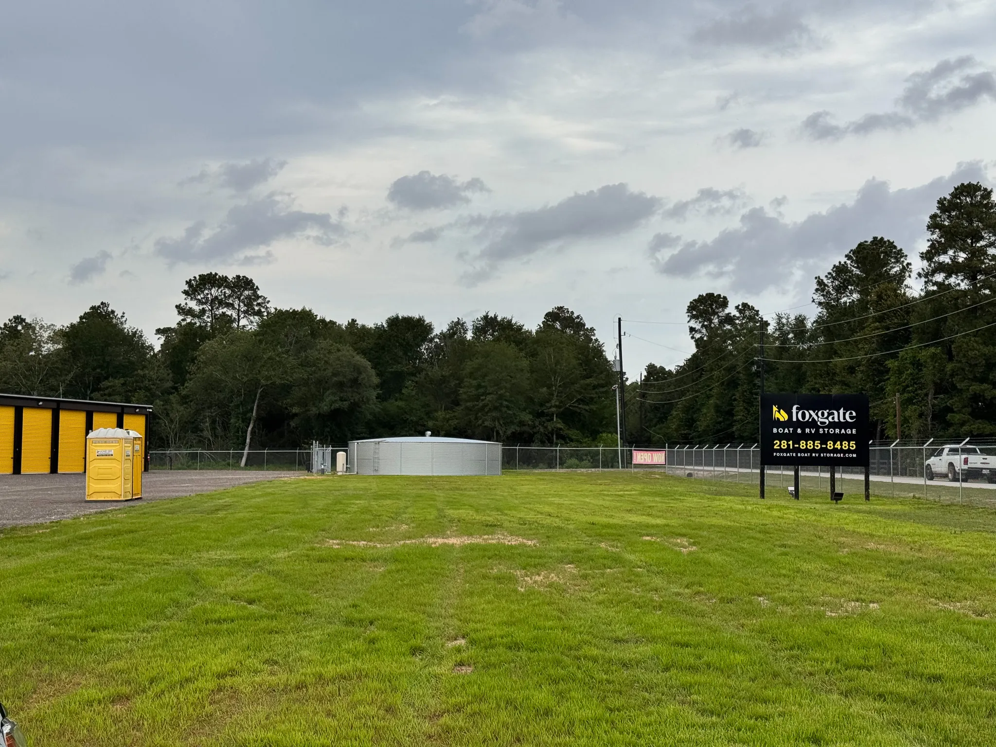 Wide aerial view of the Foxgate Boat & RV Storage facility and the wooded property around it in Magnolia, TX.
