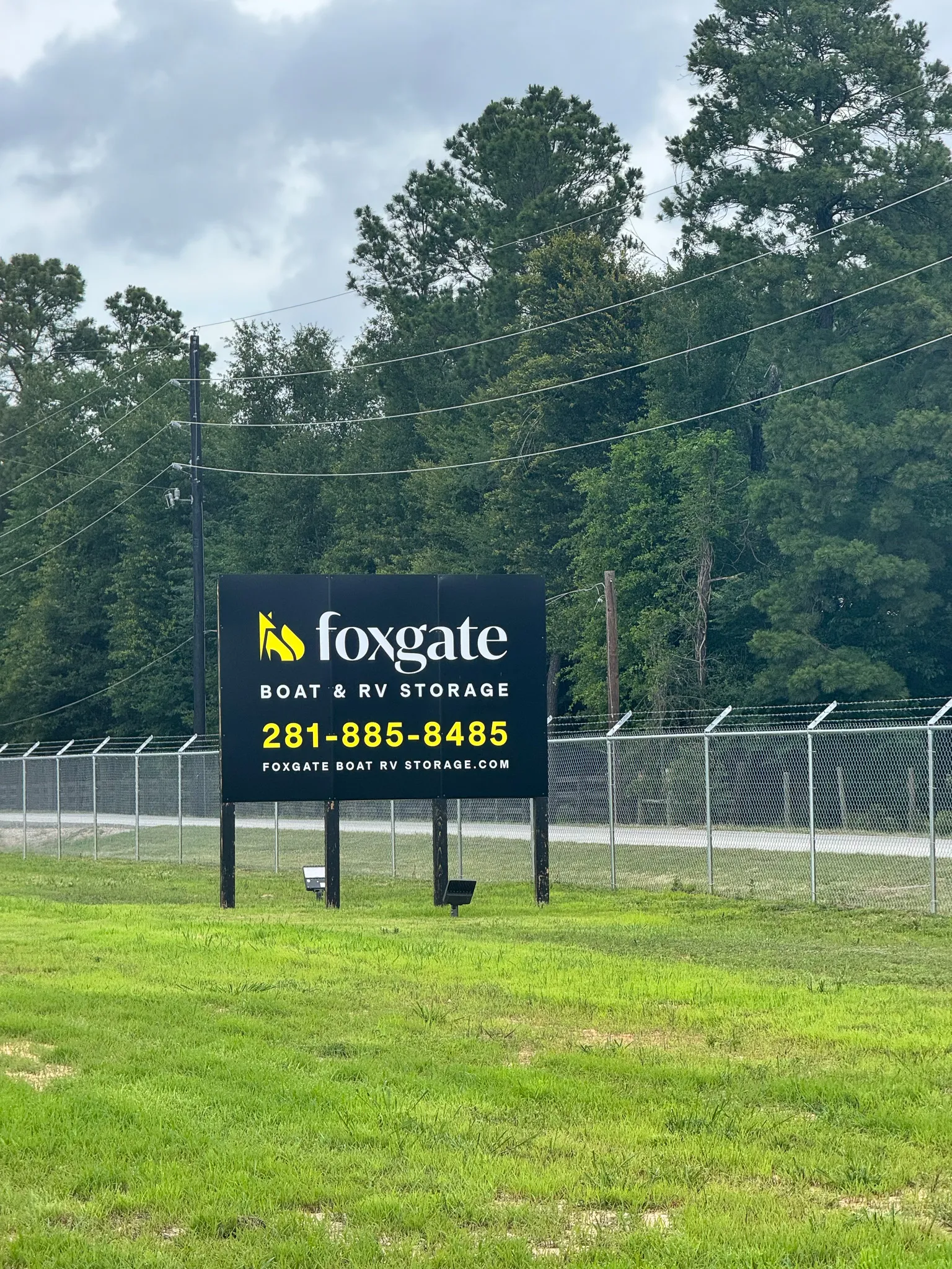 Aerial view of the Foxgate Boat & RV Storage buildings and yellow unit doors framed by surrounding woods in Magnolia, TX.