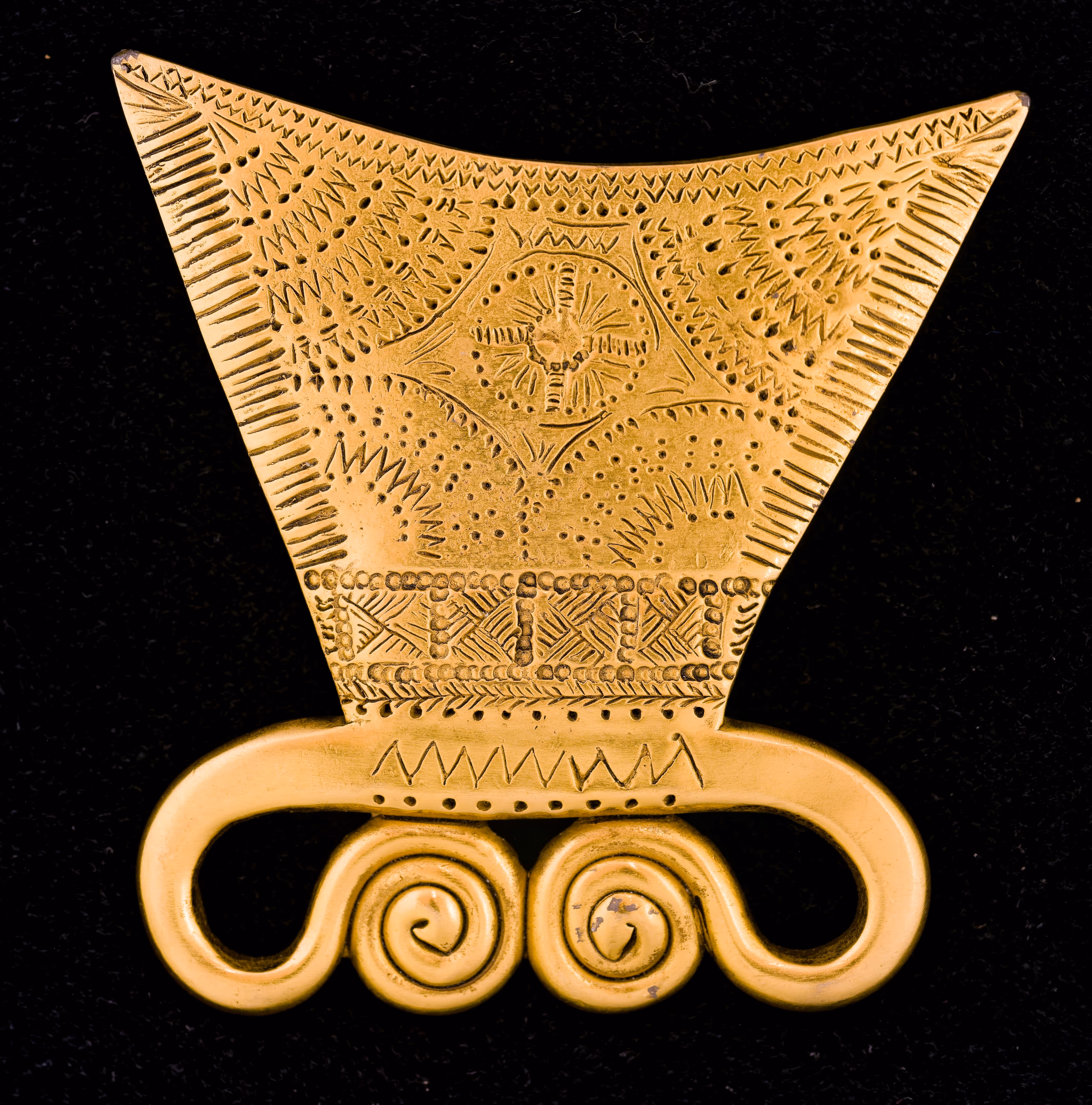 Gold ornately designed trapezoidal shaped-top belt buckle with two spiral-inspired shapes bottom