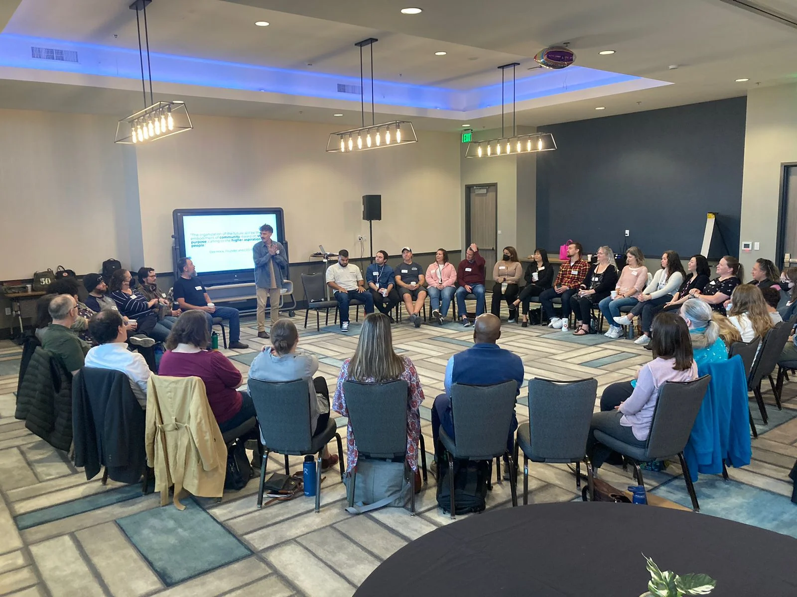 Pessoas reunidas em uma roda de conversa durante um projeto Elos, representando a colaboração entre empresas, governos e organizações em temas de cultura organizacional, engajamento e inovação social.
