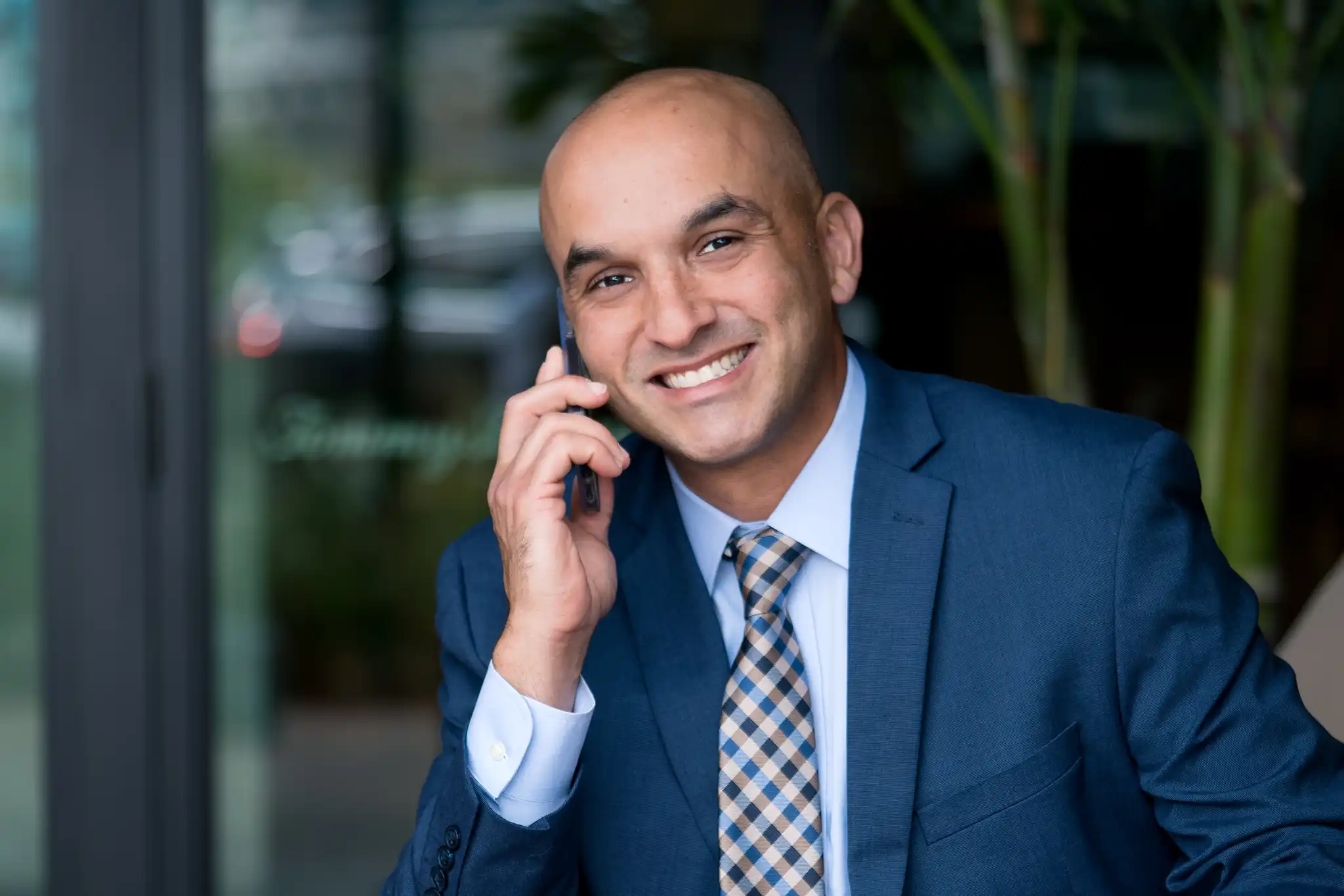 Kristopher Torres, Esq., Florida personal injury attorney, smiling while reviewing a message on his phone