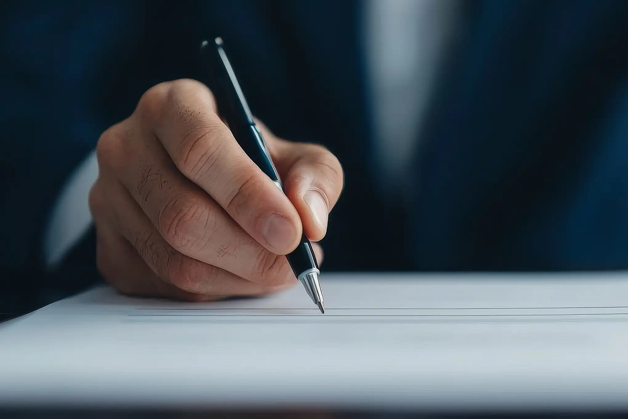 Close-up of a professional writing on legal documents, symbolizing strong legal representation and attention to detail.