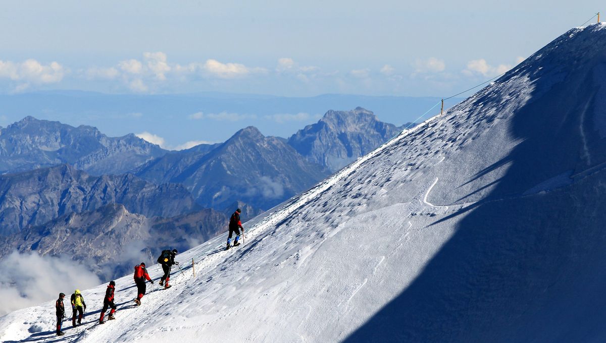 Image d'alpinistes encordés qui atteignent un sommet