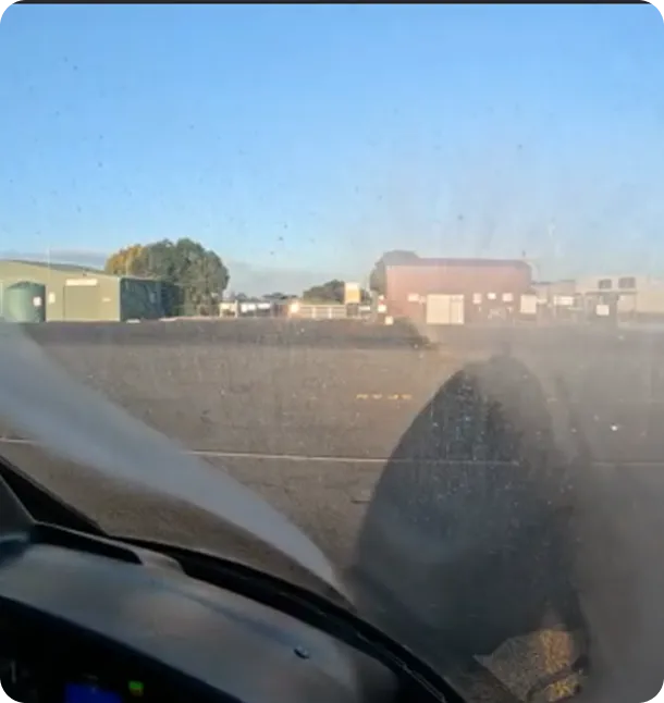 View from inside a small aircraft cockpit looking out at the runway with a propeller visible and a clear blue sky.