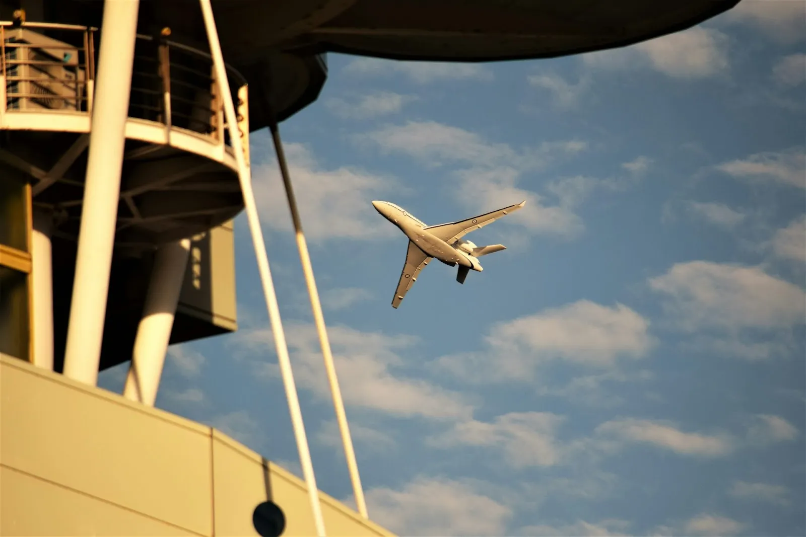 A plane taking off from an airport from the perspective of next to the traffic control tower