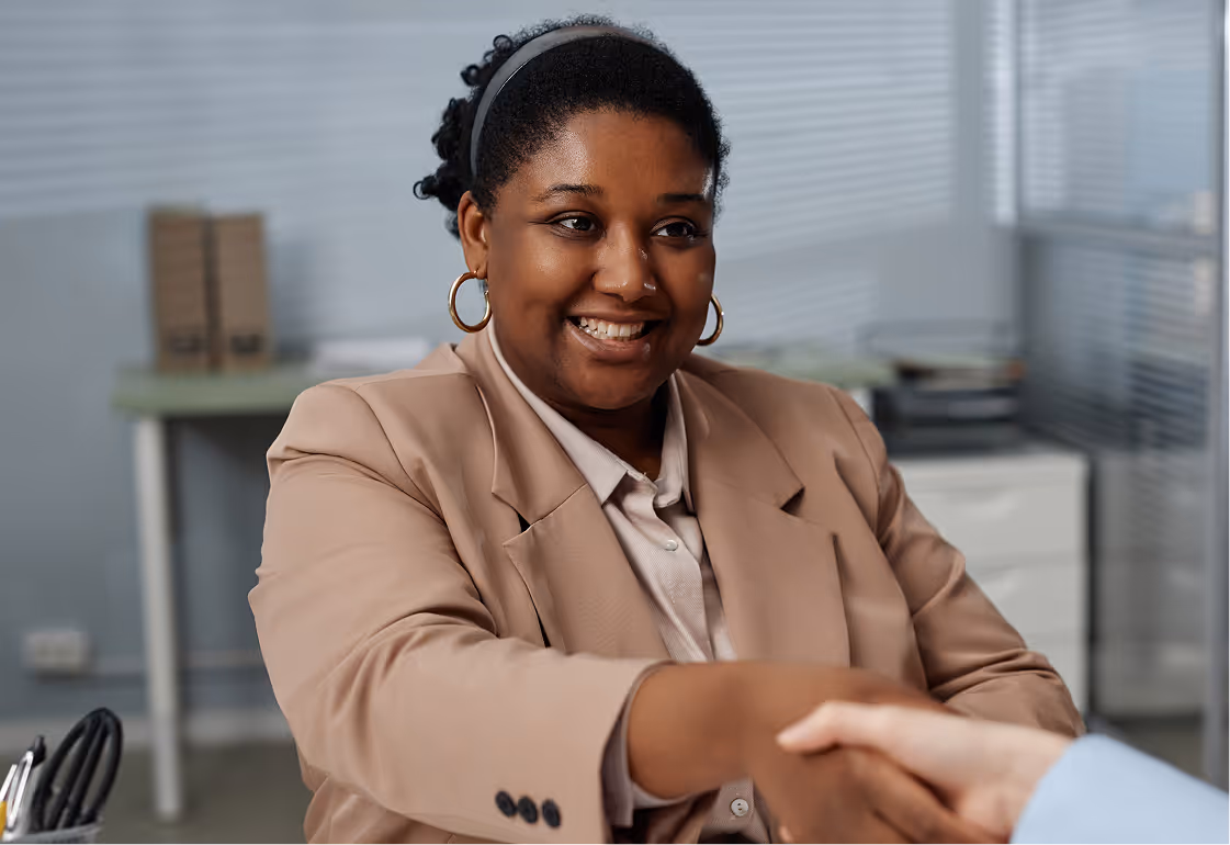 HR manager welcoming employees with a friendly handshake during a wellness session.