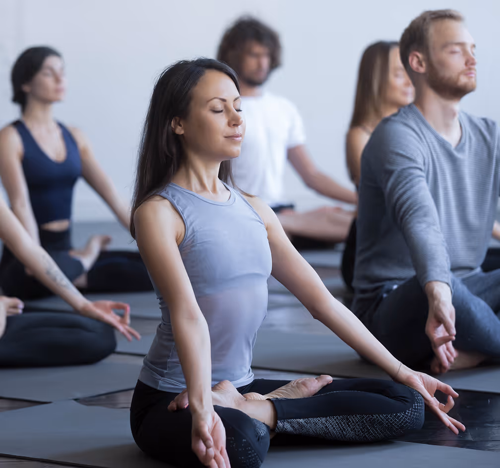 woman sitting in a yoga class with other classmates